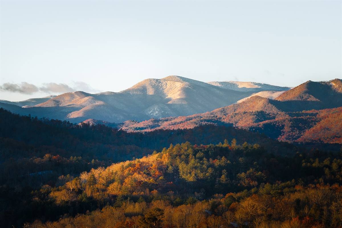 Distant mountain tops showing off the first snow of the season with the last autumn leaves hanging on in the low valleys❄️🍂