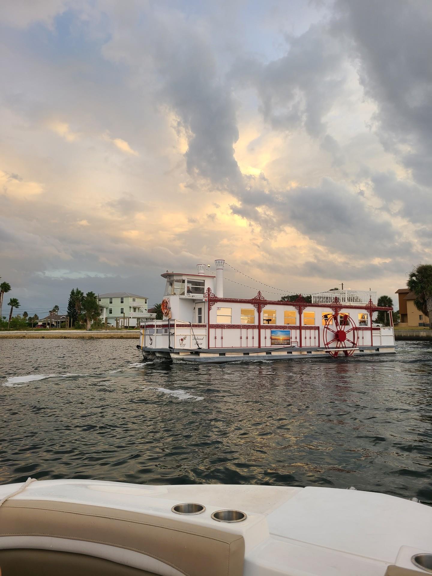 As the sun dips towards the horizon, painting the sky with a palette of warm hues, a graceful paddle boat glides across the water's reflective surface. It's a charming nod to a bygone era, its wheel a testament to timeless adventure. This tranquil scene offers a glimpse into laid-back river life, where each gentle wave tells a story of leisurely journeys and picturesque sunsets. #PaddleBoatElegance #RiverSerenade #SunsetVoyage #TimelessWaters 🌅🛳️🌥️💧